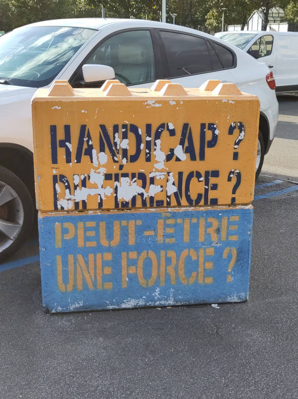 Deux blocs de béton empilés peints avec les messages : Handicap ? Différence ? Peut-être une force ?